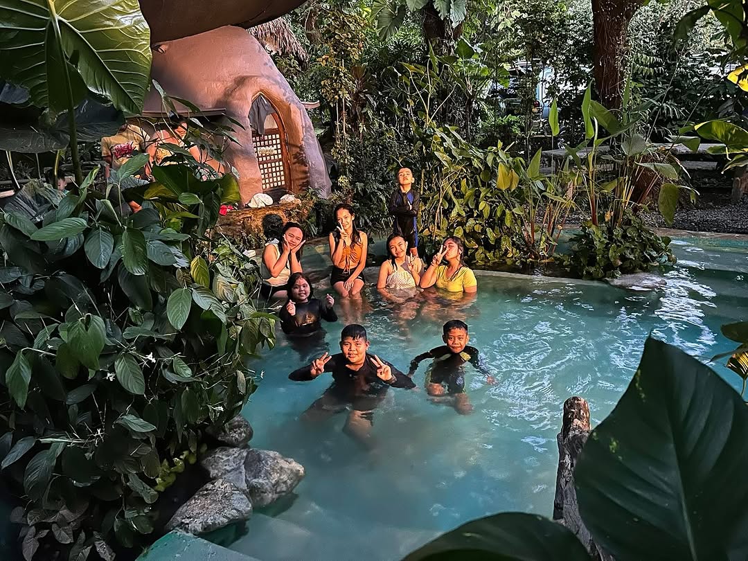 Children and adults in natural pool at Kapusod